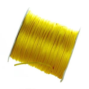 Close-up of bright yellow silky nylon cord spool for DIY knotting and braiding