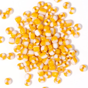 Dettaglio di perline in vetro a righe gialle e bianche da 4mm con finitura liscia
