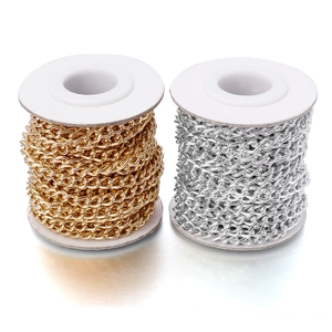 Detail von gold- und silbernen Aluminium-Gliederketten auf weißen Spulen für DIY-Schmuck