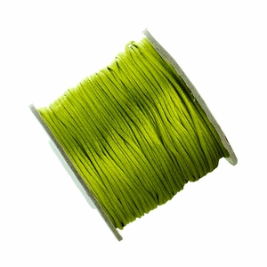 Close-up of grass green braided cord on white spool for DIY jewelry making