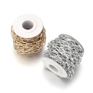 Dettaglio macro di catene a maglie paperclip oro e argento su rocchetti per gioielli fai-da-te