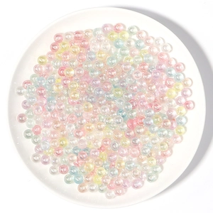 Macro de cuentas acrílicas perladas de colores en un cuenco blanco para joyería DIY