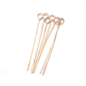 Macro shot of rose gold eye pins with closed loops for DIY jewelry making and beading