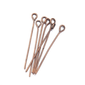 Detailed macro view of bronze tone 9-shaped eye pins for DIY jewelry making and crafting