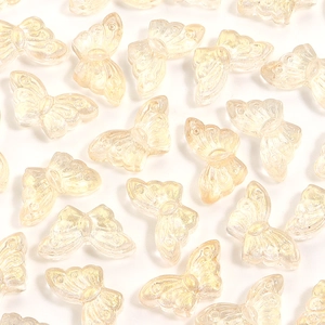 Macro detail of champagne gold translucent glass butterfly beads with iridescent texture