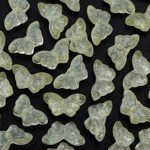 Detail of light green butterfly beads with textured wings for DIY jewelry making projects