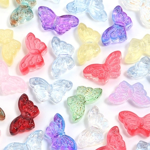 Macro view of transparent colorful butterfly beads with intricate gold foil craft details
