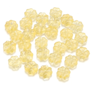 Vista macro de cuentas de vidrio esmerilado con forma de trébol amarillo para joyería DIY