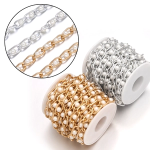 Macro detail of pearl chain accessory for bags showing gold and silver finishes