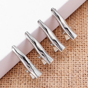 Four-piece set of silver metal alligator hair clips with non-slip teeth on textured background