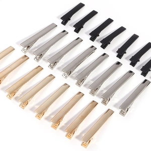 Detail of square flat metal alligator hair clips with serrated edges in black gold and silver