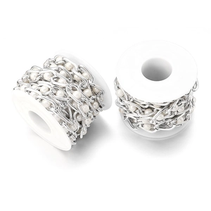 Detail of silver metal chain with white pearls on spools for DIY handbag strap accessories