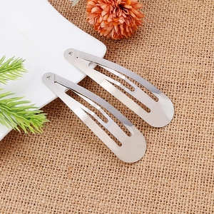 Silver teardrop metal hair clips with mirror finish on a white plate backdrop