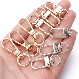 Zinc alloy lobster clasps in gold and silver colors held in hand for scale and size