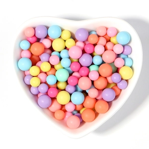 Perles en acrylique macaron colorées dans un bol en céramique pour bijoux fait main