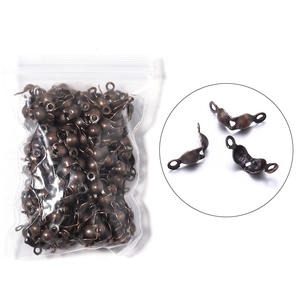 Macro detail of bronze double-loop jewelry fold-over bead crimp covers in bulk packaging