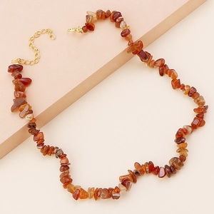 Close-up of irregular red agate stone beads with gold lobster clasp and extension chain