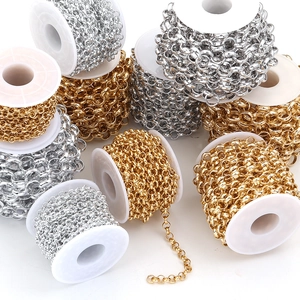 Detailed view of silver and gold rolo chains on white spools for DIY jewelry making