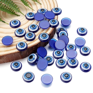 Flat round blue resin evil eye charms for DIY jewelry making on wooden background