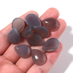 Close-up of ten teardrop shaped grey-purple chalcedony cabochons for jewelry making