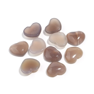 Macro shot of heart-shaped grey agate stones with smooth polished finish on white surface