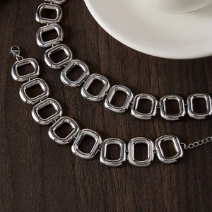 Dettaglio macro di una collana in acciaio al titanio argento con maglie rettangolari