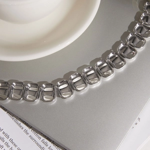 Primo piano di collana in acciaio al titanio argento con maglie rettangolari eleganti.