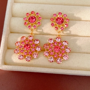 Primer plano detallado de elegantes pendientes vintage dorados con cristales rosas