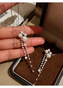 Close-up of elegant long tassel necklace with white pearls and sparkling zircons