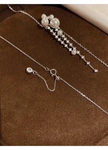 Macro detail view of a silver tassel necklace with pearls and sparkling zircons
