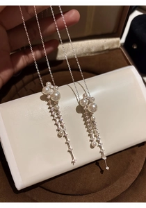 Close-up view of an elegant long pearl and zircon tassel necklace with brilliant luster
