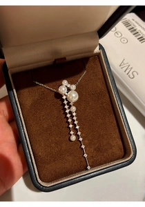 Elegant long pearl and zircon tassel pendant necklace presented in a luxury jewelry box