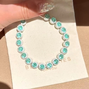 Close-up of a silver zircon bracelet with mint green halo-set gemstones