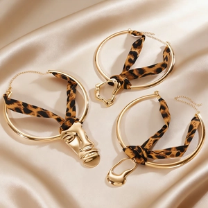Detailed view of leopard print silk ribbon chokers with irregular liquid gold pendants.