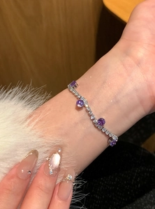 Detailansicht eines eleganten lila Zirkon-Tennisarmbands an einem Handgelenk