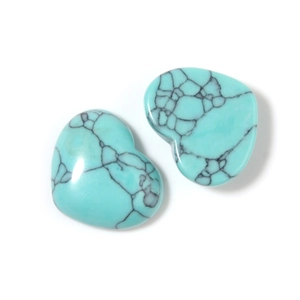 Close-up of heart-shaped blue turquoise stones with natural black matrix veins