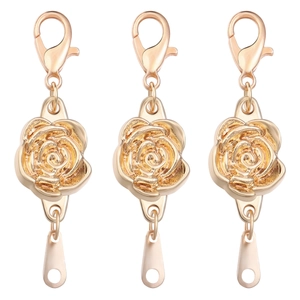 Three golden rose-shaped magnetic jewelry clasps with a polished metallic finish