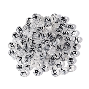 Macro view of clear acrylic alphabet beads with black letters for DIY jewelry making