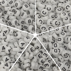Détail de perles alphabet en acrylique blanc A-E pour création de bijoux et bracelets