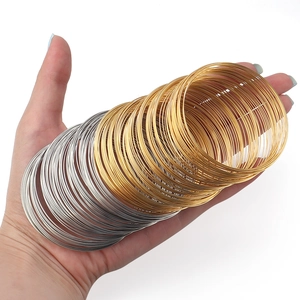 Gold and silver memory wire coils for DIY jewelry making handheld on white background
