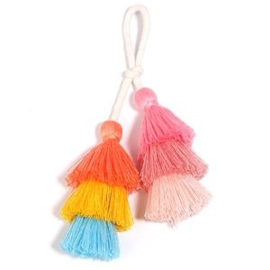 Close-up of three-tier colorful cotton tassel bag charm with braided rope loop