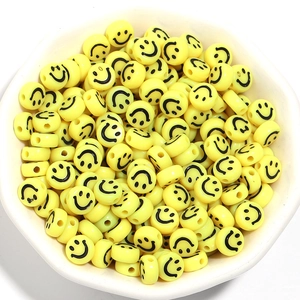 Bulk 7mm yellow acrylic smiley face beads in a white bowl for DIY bracelet jewelry making