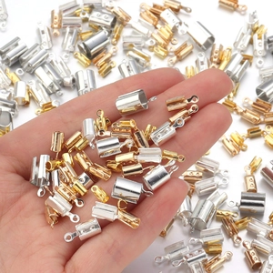 Gold- und silberfarbene U-förmige Bandklemmen für DIY-Schmuck auf weißem Hintergrund
