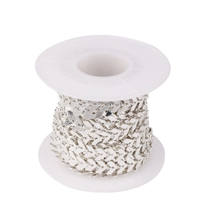 Primer plano de cadena chevron plateada de 6mm en carrete blanco para joyería DIY
