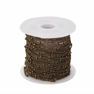 Detail of 1.5mm vintage bronze bead chain neatly wound on white spool for jewelry DIY