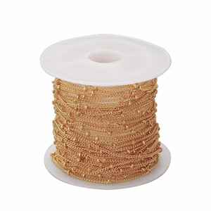Detailed close-up of 1.5mm golden satellite bead chain on a white spool for DIY jewelry