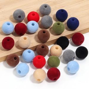 Detalle macro de cuentas flocadas de colores de 16 mm con agujeros para joyería DIY