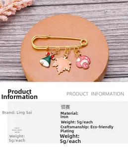 Detalle de broche de imperdible dorado con dijes de hoja de membrillo y hongo
