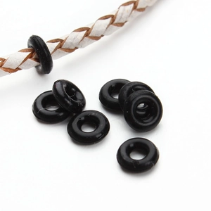 Makroaufnahme von 6/7mm schwarzen Silikon-Stoppringen auf Lederkordel für DIY-Schmuck