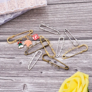 DIY gold safety pin base with three loops showing red mushroom and maple leaf charms